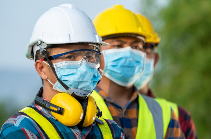 Workers wear protective face masks for safety working at solar power station,Coronavirus has turned into a global emergency.